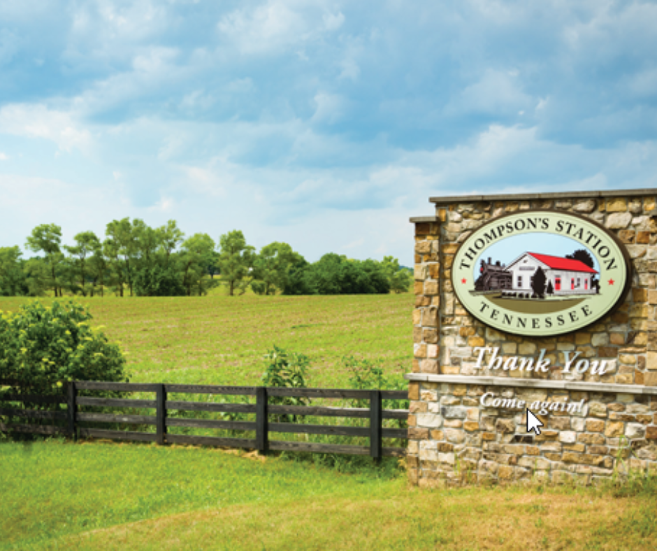 Thompson's Station welcome sign with scenic fields and trees, highlighting rural charm in Middle Tennessee.