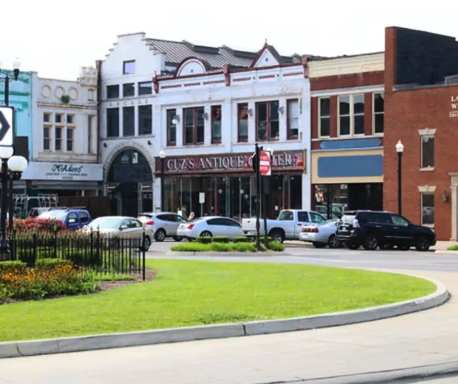 Historic storefronts in Davidson County, including Cuz's Antique Center, showcasing local businesses and community charm, surrounded by greenery and traffic circle.